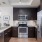 Quartz countertops and dark cabinets in apartment kitchen